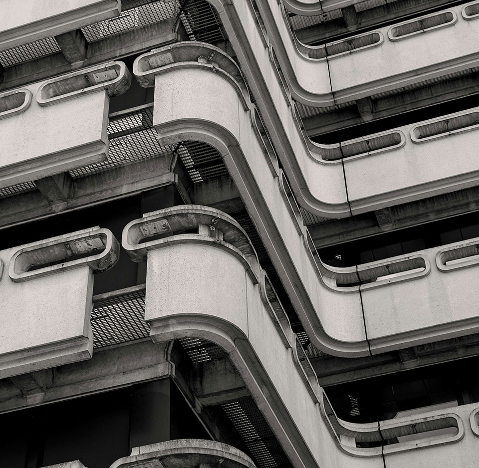 The exterior balconies of a brutalist style building juxtaposes soft and angular shapes.