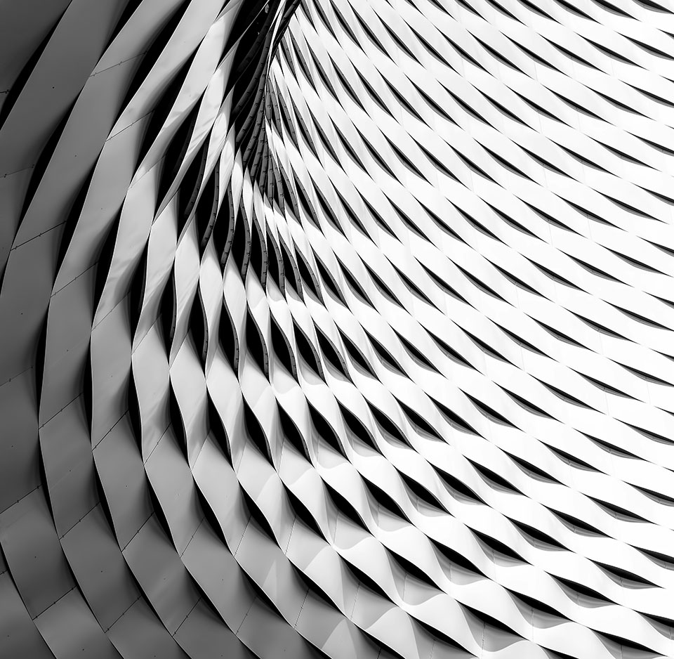 The interior facade of a curved wall adorned with metal plating looks like scales on a dragon.