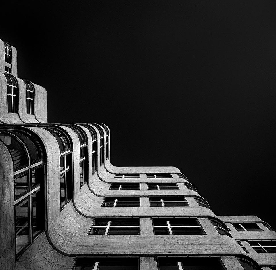 The exterior facade and roofline of a building create interesting zig-zag patterns against the sky.